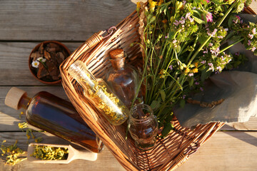 Tincture, flowers and bark chips on wooden table, top view