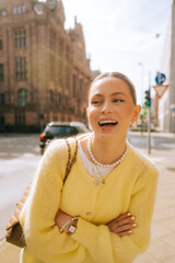 Portrait of young attractive woman fashion model posing outdoor at city street .