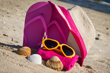 Accessories for relax on beach. Straw hat, flip flop, sunglasses and towel. Summertime