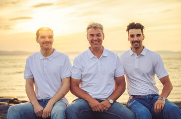 family at beach on summer time, father and is two son having fun