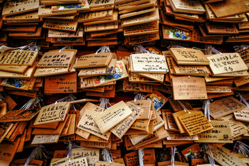 Close-up of stacks of wooden plaques (Emas) with messages written to the spirits of Shinto gods, Japan
