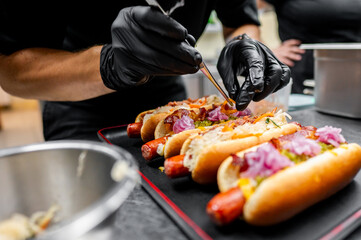 Chef hand cooking set hot dog on kitchen