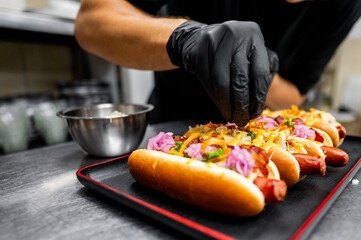 Chef hand cooking set hot dog on kitchen