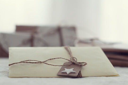 Close-up of handcrafted Letters and envelopes tied with string and a gift tag on a table