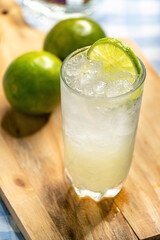 Long iced lemon-based drink on wooden board