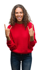 Young hispanic woman wearing red sweater shouting with crazy expression doing rock symbol with hands up. Music star. Heavy concept.