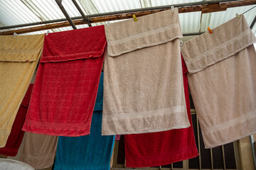 Colorful towels hang on a wire, drying in the breeze after being freshly washed, adding a vibrant touch to the outdoors.