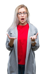 Young blonde business woman wearing fashion jacket over isolated background afraid and shocked with surprise expression, fear and excited face.