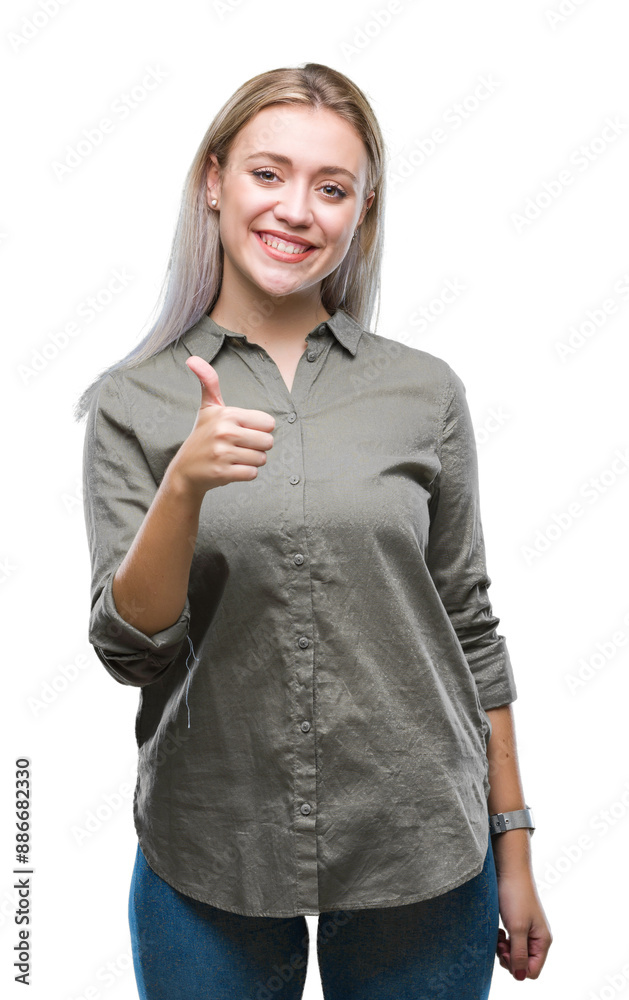 Sticker young blonde business woman over isolated background doing happy thumbs up gesture with hand. approv