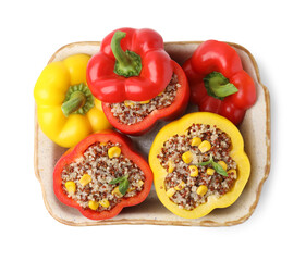 Quinoa stuffed bell peppers and basil in baking dish isolated on white, top view