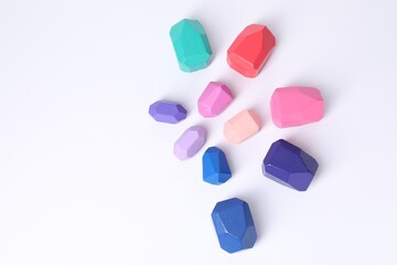 Many colorful balancing stones on white background, flat lay. Space for text