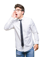 Young business man wearing glasses over isolated background shouting and screaming loud to side with hand on mouth. Communication concept.