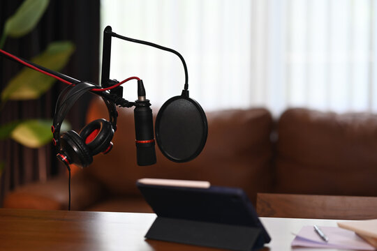 Ready for Podcast Recording, A professional podcast setup with a microphone, headphones, and a tablet, prepared for recording in a cozy studio environment