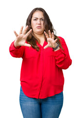 Beautiful plus size young business woman over isolated background afraid and terrified with fear expression stop gesture with hands, shouting in shock. Panic concept.