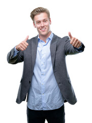 Young handsome blond business man approving doing positive gesture with hand, thumbs up smiling and happy for success. Looking at the camera, winner gesture.