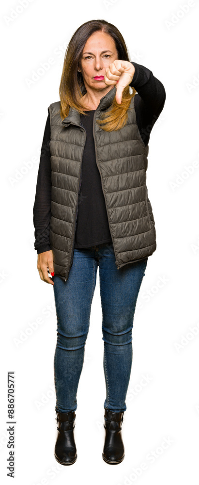 Wall mural beautiful middle age woman wearing winter vest looking unhappy and angry showing rejection and negat