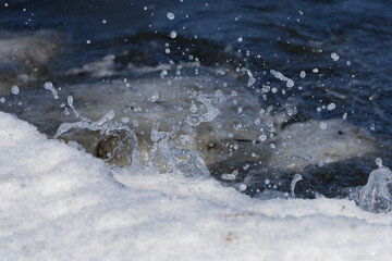 冬の根室湾に漂着した流氷と波しぶき