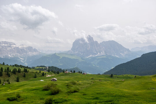 Wandern auf der Seceda Alm im Naturpark Puez-Geisler. (S&uuml;dtirol, Italien) Saftig gr&uuml;ne Wiesen und urige H&uuml;tten vor den Gipfeln der Dolomiten.