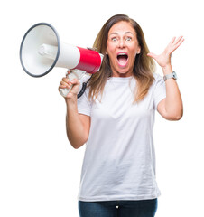 Middle age hispanic woman yelling through megaphone over isolated background very happy and excited, winner expression celebrating victory screaming with big smile and raised hands