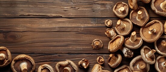 Fototapeta premium Top view of shiitake mushrooms dried on a wooden table with space for additional images