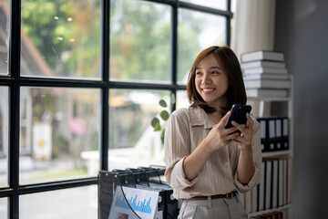 A woman is smiling and holding a cell phone