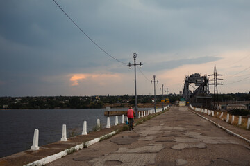 Obraz premium A man in a red T-shirt rides a bicycle on a broken road