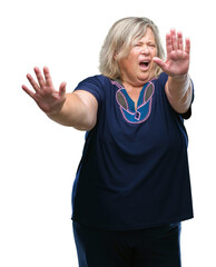 Senior plus size caucasian woman over isolated background afraid and terrified with fear expression stop gesture with hands, shouting in shock. Panic concept.