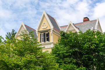 Beautifully designed Victorian-style house, partially obscured by lush green trees, Newton,...