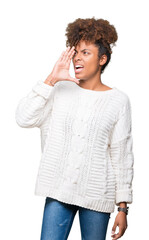 Beautiful young african american woman wearing winter sweater over isolated background shouting and screaming loud to side with hand on mouth. Communication concept.