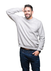 Fototapeta premium Young handsome man wearing sweatshirt over isolated background Smiling confident touching hair with hand up gesture, posing attractive