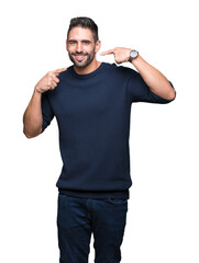 Young handsome man wearing sweater over isolated background smiling confident showing and pointing with fingers teeth and mouth. Health concept.