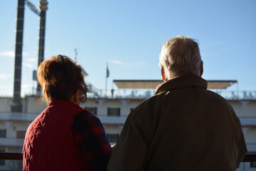 Elderly couple looking into distance at lake
