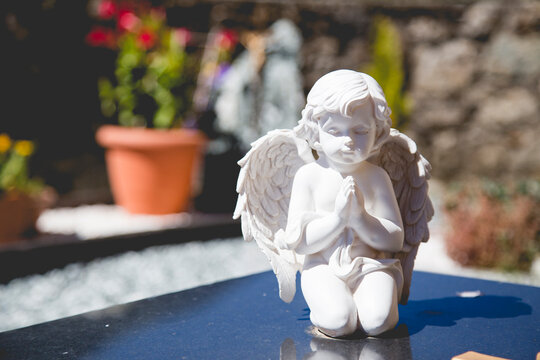 Close-up of white praying angel statue on a grave in a Spanish cemetery, Spain