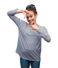 Young braided hair african american girl wearing sweater over isolated background smiling making frame with hands and fingers with happy face. Creativity and photography concept.