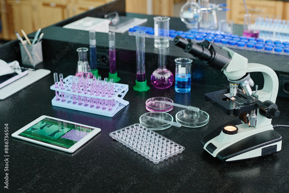 Poster workplace of modern scientist or researcher with microscope, petri dishes with pipettes, set of flas