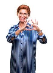 Obraz premium Atrractive senior caucasian redhead woman over isolated background smiling in love showing heart symbol and shape with hands. Romantic concept.