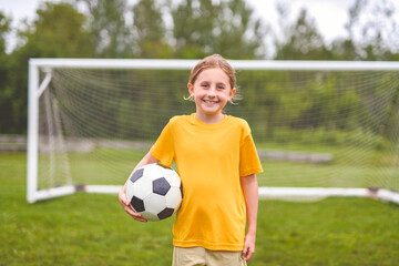 Kid play football on outdoor field at the end of the day