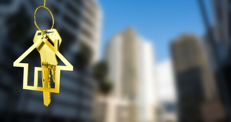 Image of hanging golden house keys against blurred view of tall buildings with copy space