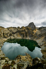 Obraz premium Photo de sommets des Pyrénées ariégeoises qui se reflètent dans un lac rond