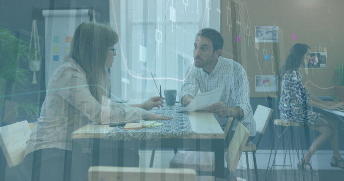 Image of multiple graphs and numbers over diverse coworkers discussing on desk in office