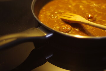 Detalle de cocina moderna con una sarten calentando lentejas calientes. Alimentación 