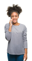 Young afro american woman talking on the phone over isolated background with a happy face standing and smiling with a confident smile showing teeth