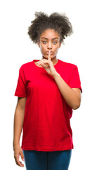 Young afro american woman over isolated background asking to be quiet with finger on lips. Silence and secret concept.