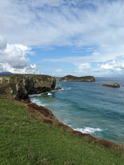 Green grassy coastline on a sunny day  in Asturias, Spain