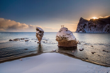 Coastal snow covered rock formations in sea at sunrise, Hokkaido, Japan