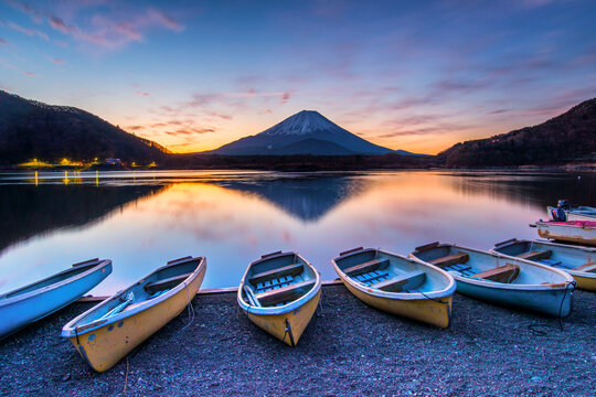 Row of boats on the shore of Lake Shoji at sunrise with Mt Fuji in the background, Yamanashi Prefecture, Honshu, Japan