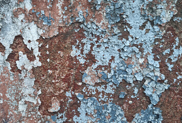 Texture of old rustic wall covered with gray and blue stucco. Multilayers of old paint on the wall....