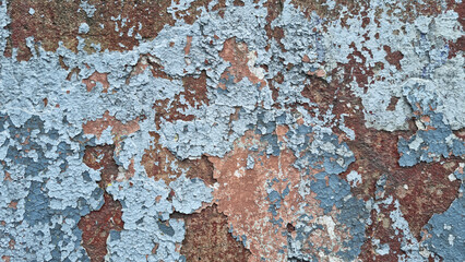 Texture of old rustic wall covered with gray and blue stucco. Multilayers of old paint on the wall. Textured background. Selective focus