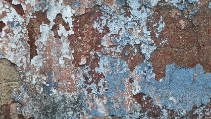 Texture of old rustic wall covered with gray and blue stucco. Multilayers of old paint on the wall....