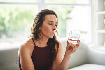 alone depressed woman drink booze on sofa at home. Treatment of alcohol addiction, suffer abuse...